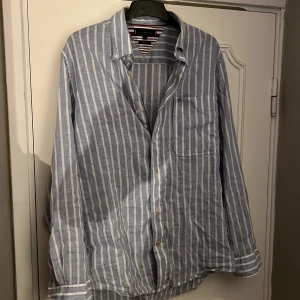 Tommy Hilfiger linneskjorta stl M - Tröjan är i stl M men passar även L. Säljer då den är lite för stor för mig så den har inte kommit till så mycket användning. Den blåa färgen är lite ljusare än vad man ser på bilderna.  Nypris är ca 1200kr och tröjan är så gott som ny. 