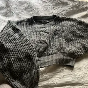 Fin grå stickad tröja från NAKD, tröjan har detaljer som ”flätan” fram och balongärmar. Köpt för många år sedan och lite nopprig men inget som stör