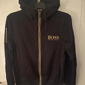 Hugo Boss zip hoodie - Storlek M men är liten i storlek då den även passar mig som brukar ha S Skick: Nyskick, använd väldigt få gånger Exklusiv då den inte finns att köpa längre 2000 nypris Pris kan diskuteras vid snabb affär, hör av er för mer bilder på tröjan