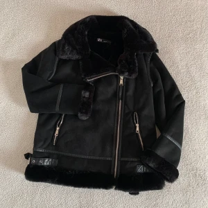 ZARA pilotjacka i mocka med teddyfoder  - Otroligt snygg pilotjacka från ZARA i mocka med detaljer av supermjukt och mysigt teddyfoder, fodrad likadant på insidan. Snygga detaljer i läder och silverspännen. Använd endast en gång. Ordinariepris 1299kr. Storlek XS men passar även S och M.