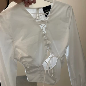 Vit blus - En supersnygg helt oanvänd blus från Bershka med snörning där fram & öppen i ryggen😍