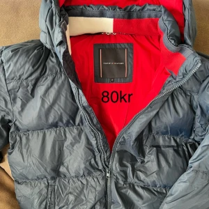 Jacka Tommy Hilfiger  - Mörkblå jacka i strl 176, med liten skåda (se bild). 