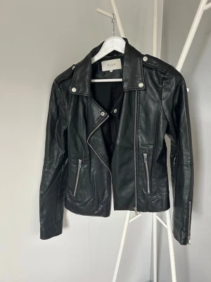 Svart skinnjacka från Vila - Snygg svart skinnjacka från Vila med silvriga detaljer. Fint skick 🥰