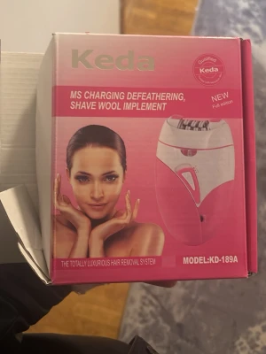 Keda hårborttagningsapparat rosa - Elektrisk hårborttagningsapparat från Keda i rosa och vitt. Laddningsbar modell KD-189A, designad för effektiv hårborttagning. Smidig form som ligger bra i handen och passar för användning på olika delar av kroppen. Den e helllt ny oanvänd . 
