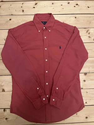 Röd ralph lauren, slim fit strl M - Superfin herr Ralph lauren i strl M slim fit som är i absoluta toppskick. Inga defekter och kan absolut ge fler bilder vid behov.