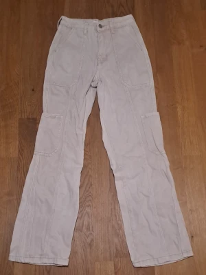 Vita byxor med raka ben - Säljer ett par vita byxor från BP i 100% bomull. Byxorna har synliga sömmar och stängs med knapp och dragkedja. 