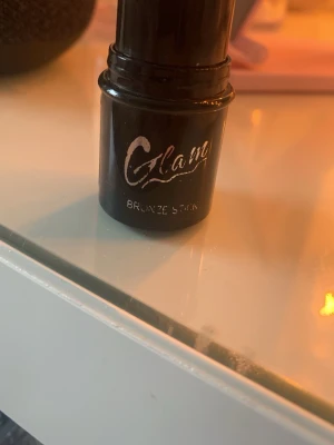 Glam Bronze Stick bronzer - Bronzer i praktisk stickform från Glam. Färgen är en varm bronzig ton som ger huden en solkysst look. Förpackningen är svart med silvrig text och enkel att ta med i väskan. Perfekt för att snabbt fräscha upp ansiktet och skapa glow.