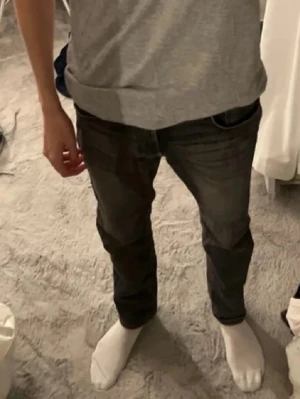 Svarta slim fit jeans - Snygga svarta slim fit jeans med klassisk femficksdesign och diskreta slitningar. Jeansen har normal midja och smal passform hela vägen ner. Perfekta för en stilren och modern look. Storlek 30/32.