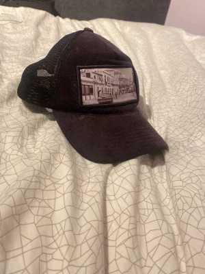 Svart truckerkeps med stadsmotiv - Sliten Montez keps väldigt fräs fof men den har varit använda många fina gånger, det går dock inte köpa de någonstans längre tror jag så ja.
