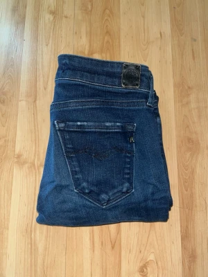 Repaly Hyperflex jeans  - Mörkblåa Reolay Hyperflex Jeans med en skinny passform. Obs jeansen har ett litet hål vid vänster sida och små slitningar vid bakfickorna. Midja 30cm, längd 95cm. L storleken saknas men jag uppskattar till L30 - men utgå efter mått. JAG SKICKAR EJ FLER BILDER NÄR JAG BÄR JEANSEN! för bättre inblick i passformen rekommenderar jag att googla på modellnamnet. För storleksguide kolla måtten noggrant då jeansen alltid kan vara uppsydda heller krympta och jag ej tar emot returer :) s6,4