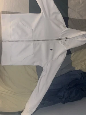 Vit polo Ralph zip hoodie.  - Snygg vit hoodie från Polo Ralph Lauren med dragkedja och huva. Klassisk design med fickor framtill och den ikoniska lilla loggan broderad på bröstet. Tillverkad i mjukt bomullsmaterial som är perfekt för chill dagar.