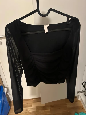 Svart mesh  festtopp  - Trendig svart topp från Nelly, oanvänd med prislappen kvar på 