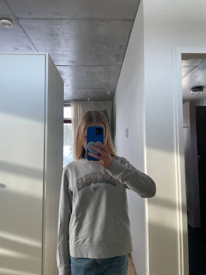 Zadig voltaire tröja med AMOUR-tryck - Snygg grå sweatshirt med färgglatt AMOUR-tryck på bröstet och rund hals. Tröjan har en avslappnad passform och långa ärmar, perfekt för en casual stil. Passar till jeans eller leggings för en chill look.