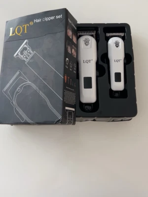 LQT hårtrimmer set vit - Säljer ett LQT hårtrimmer set med två vita trimmers i olika storlekar. Båda har svart detalj och logga framtill. Perfekt för att fixa frisyrer hemma. Kommer i originalförpackning med plats för båda maskinerna.