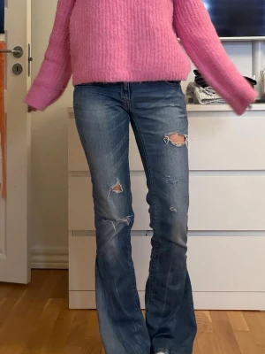 Blå bootcut jeans - Snygga bootcut jeans från replay. Köpta här på Plick, tjejen jag köpte av har sytt om jeansen och gjort hålen själv. Midjemått 36cm innebenslängd 79cm