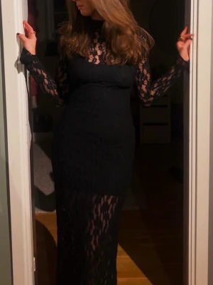 INTRESSEKOLL lång svart spetsklänning  - Elegant svart långklänning med transparent spets över hela klänningen och långa ärmar. Klänningen har en figurnära passform, hög hals och extra långa armar med slits längst ut. Köpt på Zara för flera år sedan så finns ej kvar. Buda gärna så kan vi se!