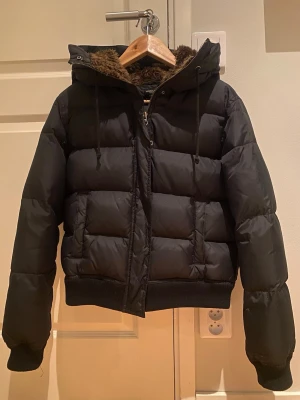 Dunjacka - Svart dunjacka med äkta dun vilket gör den varm men inte för tät. Storlek M men skulle säga att den är liten i storleken så snarare S.
