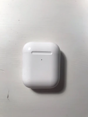 Apple AirPods 2 - Säljer ett par vita Apple AirPods 2 med det klassiska laddningsetuiet. Smidig och kompakt design i blank plast som är enkel att ta med sig överallt. Perfekt för dig som vill ha trådlösa hörlurar till mobilen eller datorn.