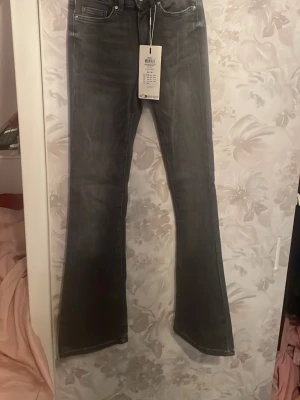 Bootcut grå jeans med utsvängda ben - ONLY FLARED BLUSH -mid waist. Stl. XS/30. Säljer ett par grå bootcut jeans med utsvängda ben och klassisk femficksdesign. Jeansen har en snygg tvättad look. Tillverkade i mjukt denimtyg. Helt oanvända med prislappen kvar. Nypris 549.95kr