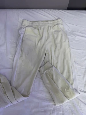 Vita mjukisbyxor från Lindex - Säljer ett par vita mjukisbyxor från Lindex med resår i midjan och sidofickor. Byxorna är gjorda i mjukt material och har en relaxed passform som är perfekt för chill dagar. Passar dig som gillar enkel och clean stil.