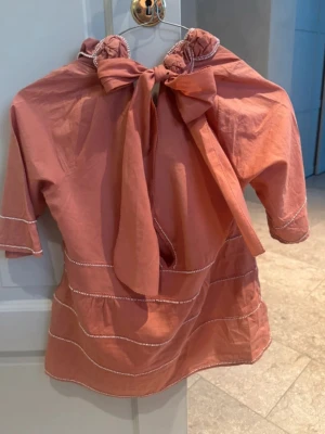 Mulberry vintage blus/topp med rosett/knytning rosa - Sååå snygg och vacker blus från lyxmärket Mulberry (äkta Mulberry). Otroligt fin med detaljer i vita pärlor. 100% bomull och med världens finaste rosett/knytning/band i ryggen. Blusen har en mini-liten slitning vid dragkedjan (under armhålan), ingenting som syns om man ej tittar jättenoga och lyfter på armhålan- annars helt fel-och fläckfri! Superskick😍💝 Skulle säga att det är en storlek S/M