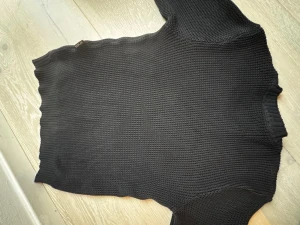 Svart stickad tröja från Replay - Snygg svart stickad tröja från Replay Premium Selection. Tröjan har en klassisk rak passform, ribbstickade muddar och är tillverkad i ett tjockare garn som ger en cool struktur. Perfekt för dig som gillar stilrena och tidlösa plagg. Ny pris runt 2000 beställde men för stor 