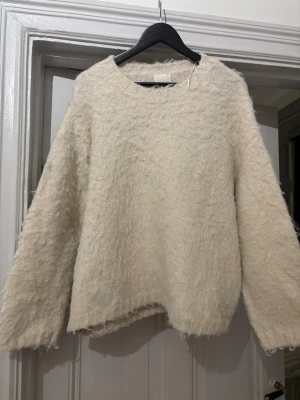 Vit fluffig stickad tröja H&M - Mysig beige stickad tröja från H&M i storlek XL. Tröjan är fluffig. Den är alltså menad att vara så och köpt så!💖💖