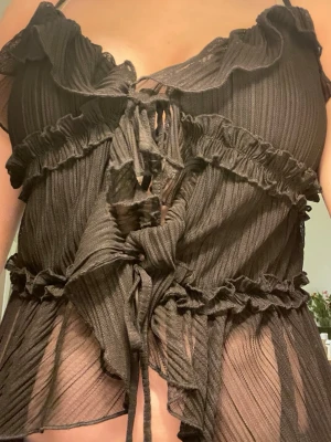 Svart volangblus med snörning - Snygg svart blus från New Yorker med tunna axelband, volangdetaljer och snörning framtill. Toppen är luftig och superfin till sommaren! 💐💞