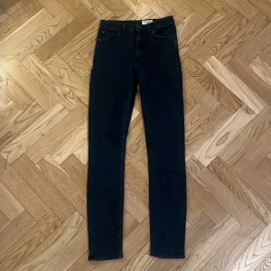 Svarta  jeans Tiger of Sweden - Snygga mörkblå  jeans från Tiger of Sweden med klassisk femficksdesign och diskreta sömmar. Jeansen har en smal passform och är tillverkade i stretchigt denimtyg för extra komfort. Perfekta för dig som gillar en stilren och modern look.