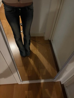 Mörkblå bootcut jeans med låg midja - Säljer ett par mörkblå bootcut jeans med låg midja. Jeansen har klassisk femficksdesign och snygga slitningar framtill för en cool look. Perfekta till vardags och matchas lätt med olika stilar.                Storlek 25/32