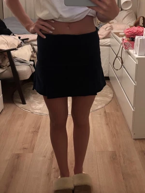 Mörkblå manchesterkjol - Säljer en mörkblå kortkjol i manchester med enkel, rak passform och diskreta sömdetaljer. Kjolen har en klassisk look och är perfekt för dig som gillar stilrena plagg med lite struktur.