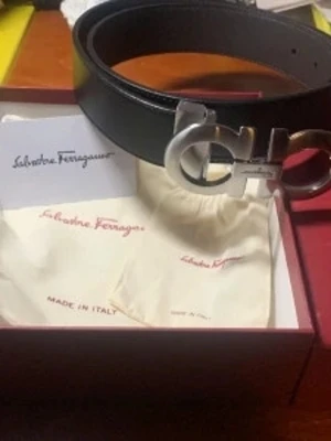 Svart Salvatore Ferragamo bälte - Snyggt svart bälte från Salvatore Ferragamo med ikoniskt silverfärgat spänne i metall. Bältet är gjort i äkta läder och har en stilren, klassisk design som passar till många olika outfits. Levereras i originalförpackning med dustbag.