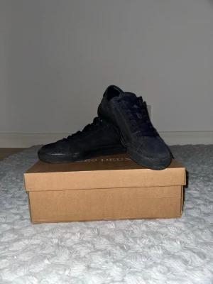 Svarta mocka sneakers från Les Deux - Mörk blå skor från Les Deux i mjuk mocka med matchande mörka skosnören och platt sula. Har använts antal gånger. köptes för 1800kr 