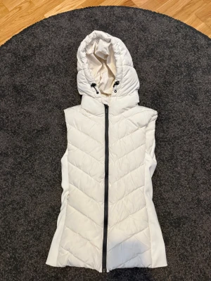 Vit dunväst från Zara - Snygg dunväst från zara med justerbar luva. Säljer då jag inte använder den längre 💗
