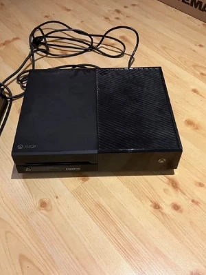 Xbox One spelkonsol svart - Säljer en svart Xbox One spelkonsol med klassisk design och HDMI-utgång. Konsolen har en matt och en glansig sida på ovansidan, och den är tillverkad i plast. Perfekt för gaming och streaming.
