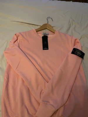 Rosa Stone Island tröja  - Säljer min helt nya Stone Island tröja (oanvänd). Stilren tröja för kyliga dagar, säljer för att de var för stor för mig.