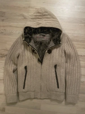 Fodrad stickad cardigan - Otroligt snygg, varm och skön vit/beige pälsfodrad stickad cardigan i toppskick. Passar perfekt nu till kallare väder. Priset kan såklart diskuteras!