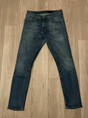 Levi's 501 mörkblå jeans herr - Snygga Levi's 511 jeans i mörkblå tvätt med klassisk femficksdesign och subtila slitningar framtill. Jeansen har normal passform med smalare ben och är tillverkade i mjukt bomullsjeansmaterial. Perfekta för en avslappnad och trendig look. Storlek 29/32
