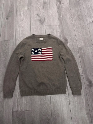 Brun USA stickad tröja - Tja den är i mycket bra skick från Selected Homme i storlek L/Xl. Den är i mycket bra skick men har några små fläckar längst ner på tröjan som säkert går bort i tvätten. Lite över fläckarna så har tröjan tappat lite tyg  på insidan som man inte märker