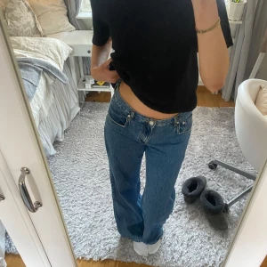 Blå jeans - Snygga blå jeans med bootcut-stil och låg midja Perfekta för en avslappnad look. Klassisk design med fem fickor och dragkedja. Pösiga
