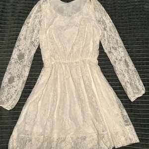 Studentklänning  - Vit spetsklänning med långärmade spetsdetaljer och en luftig kjol. Perfekt till studenten, konfirmationen eller en sommarfest💕Använd ett fåtal gånger därav ingen etikett kvar tyvärr, men passar storlek S/M