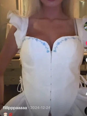 Vit korsettopp med volangdetaljer - Supersöt vit korsettopp från House of cb 💓 Toppen har hjärtformad urringning och ljusblå broderade detaljer längs kanten. Toppen har några fläckar på framsidan men är i gott skick 🫶🏼