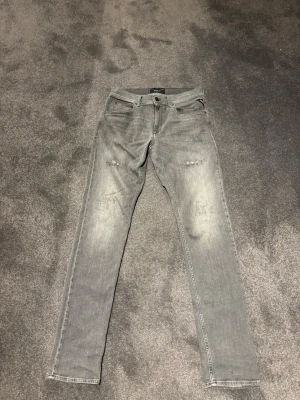 Replay jeans - Säljer ett par grå slim jeans från Replay med slitningar. Storlek 16A vilket motsvarar ungefär längden 165-175. Skick 10/10!