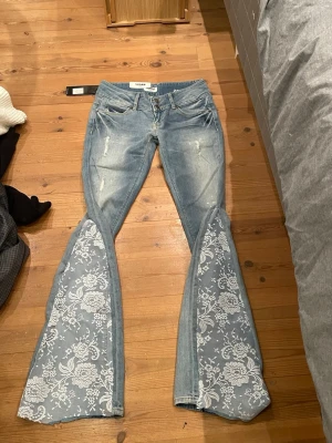 Lågmidjade jeans med spets - Säljer dessa lågmidjade jeans med slitningar på benen som är omsydda till bootcut med spets. Jätte snygga och unika men de är tyvärr för små för mig och har därför ingen bild med de på. Midjemått 35 cm och innerbenslängd 80 cm. Säljer även fler liknande jeans i min profil 💗💗