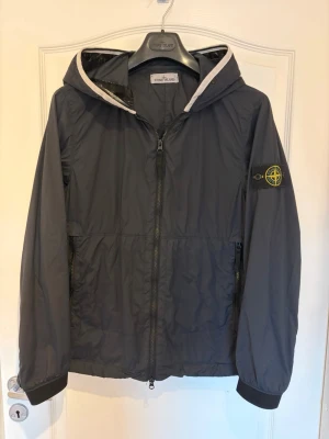 Stone Island windbreaker - Hejsan säljer nu min jacka som jag köpt i våras använd den i vår och höst den är i storlek S och passar mig som är 180 och väger 59-60 men med en åtdragbar midja passar den nog många den är köpt i deras butik och har kvitto den kostar runt 7000 ny och är i väldigt bra skick.  