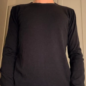 Stickad tröja  - En snygg fin stickad blå ull tröja som är i färgen marin blå och är i fint skick 