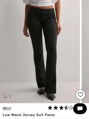 Svarta kostymbyxor från Nelly - Svarta kostymbyxor från Nelly med låg midja och bootcut-silhuett. Byxorna har två knappar framtill och är tillverkade i ett stretchigt jersey-material som ger en bekväm passform. Endast använda 2 gånger, som helt nya. Perfekta för en stilren look. Strl xs. Bara att skriva vid frågor💗