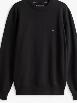 Svart Tommy Hilfiger. Dm för bilder  - Klassisk svart stickad tröja från Tommy Hilfiger med rund halsringning och diskret logga broderad på bröstet. Tröjan har ribbade muddar vid ärmslut och nederkant. Perfekt för en stilren och enkel look.