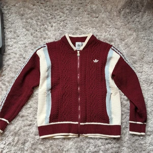 Vintage Adidas Cardigan - En stickad cardigan från Adidas, den är vintage och i NYSKICK! Passar super bra nu till vintern ☃️. Den har den klassiska adidas designen fast i högre kvalitet med stor marginal, tröjan är stickad för hand! Storlek M men passar S.