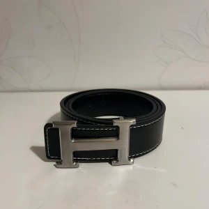 H Bälte Svart - Helt nya & högkvalitativa bälten till låga priser! Välj bland olika märken, mönster och färger. Vi fraktar din order så snabbt som möjligt och vi ser till att ditt paket är säkert packat under frakt 🚚 